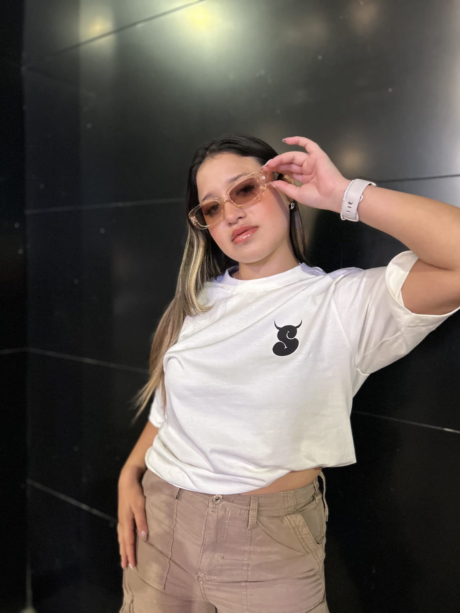 Modelo con la camiseta Intrinsic blanca frente a una pared negra