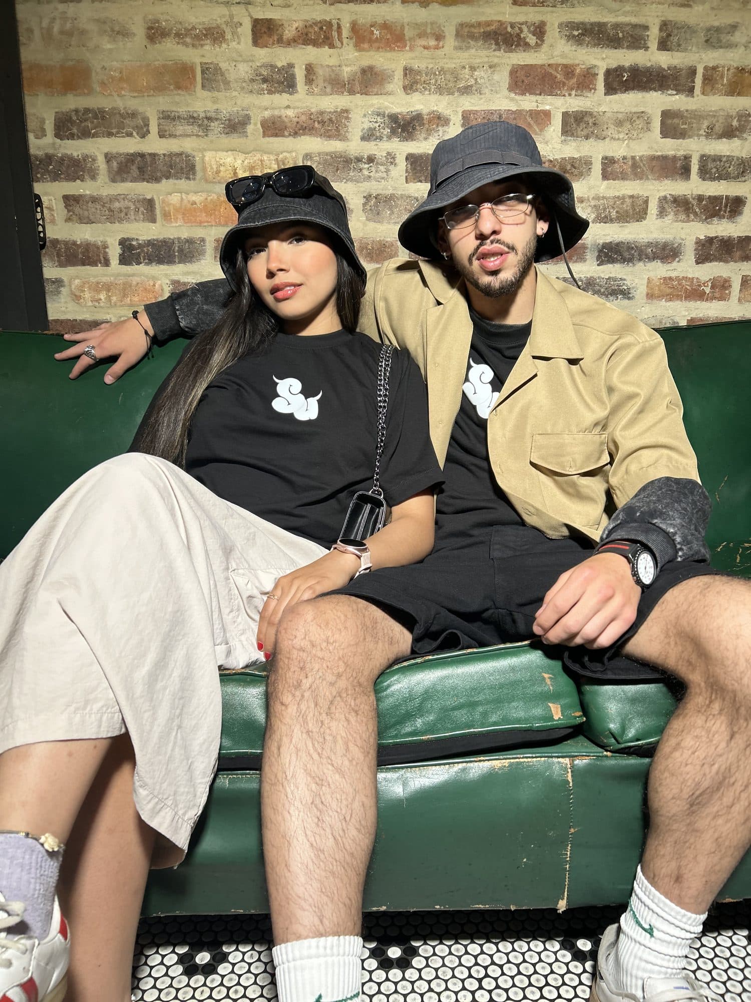 Pareja en un sofá verde de cuero con la camiseta Intrinsic negra