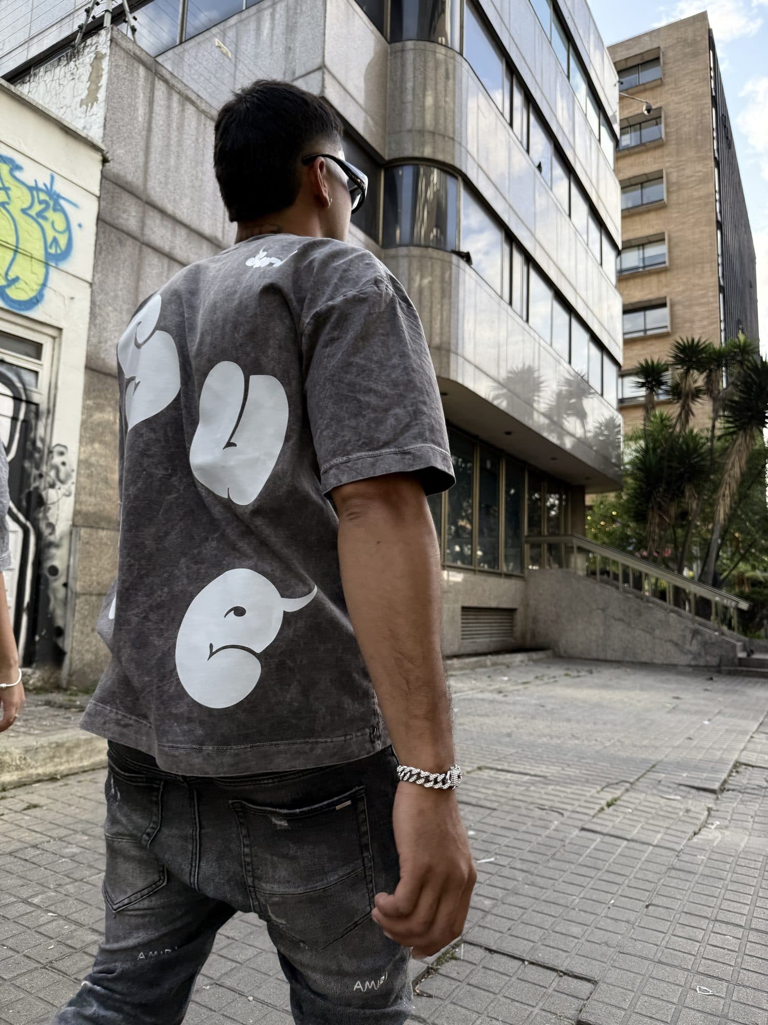 Modelo caminando de espaldas con la camiseta Niebla gris