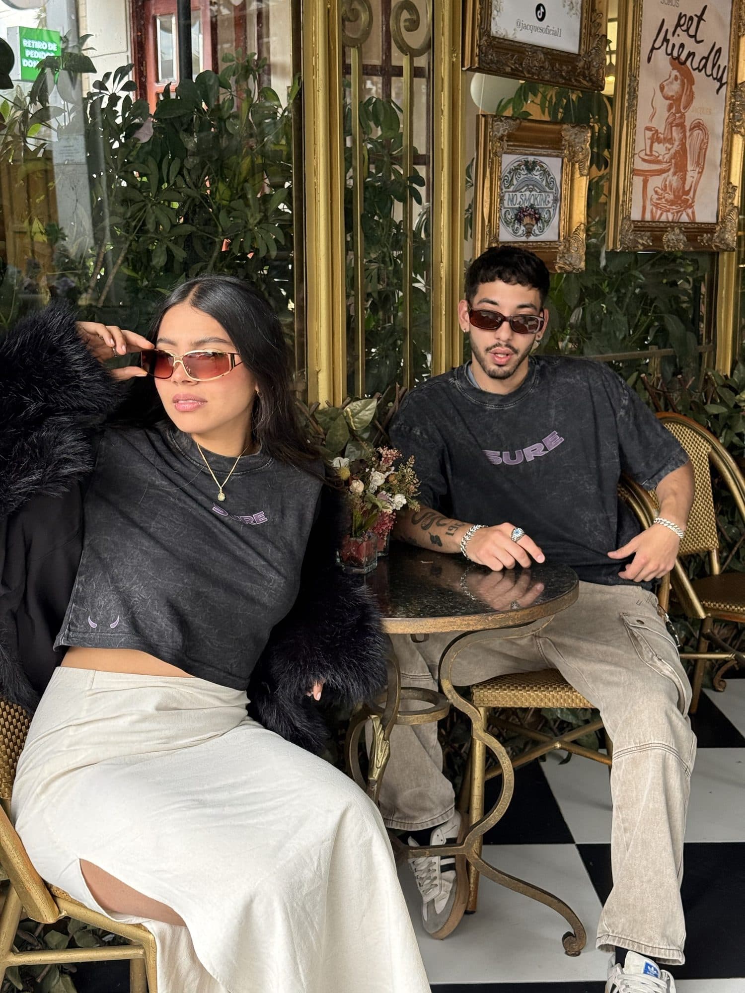Modelo con abrigo de peluche y modelo con la camiseta gris carbón en un café