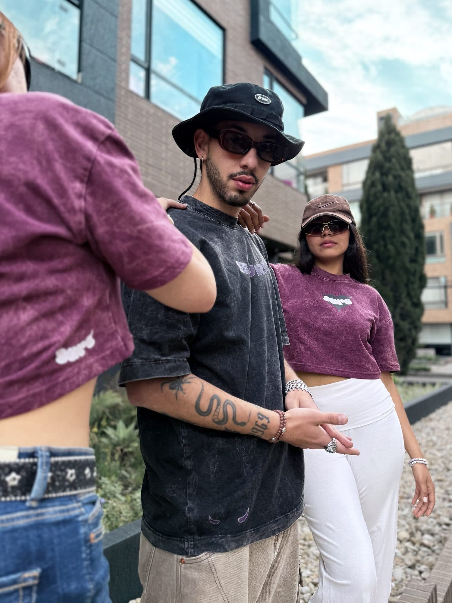 Modelo con la camiseta gris carbón y los cuernos en el ruedo, entre dos crops vino tinto