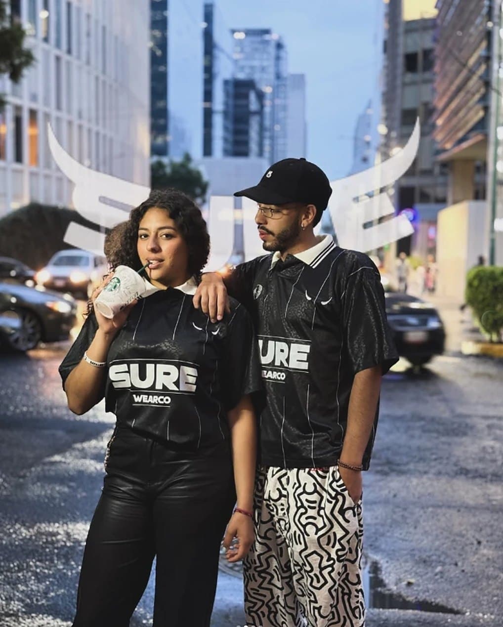 Pareja en la calle con la camiseta Sure26