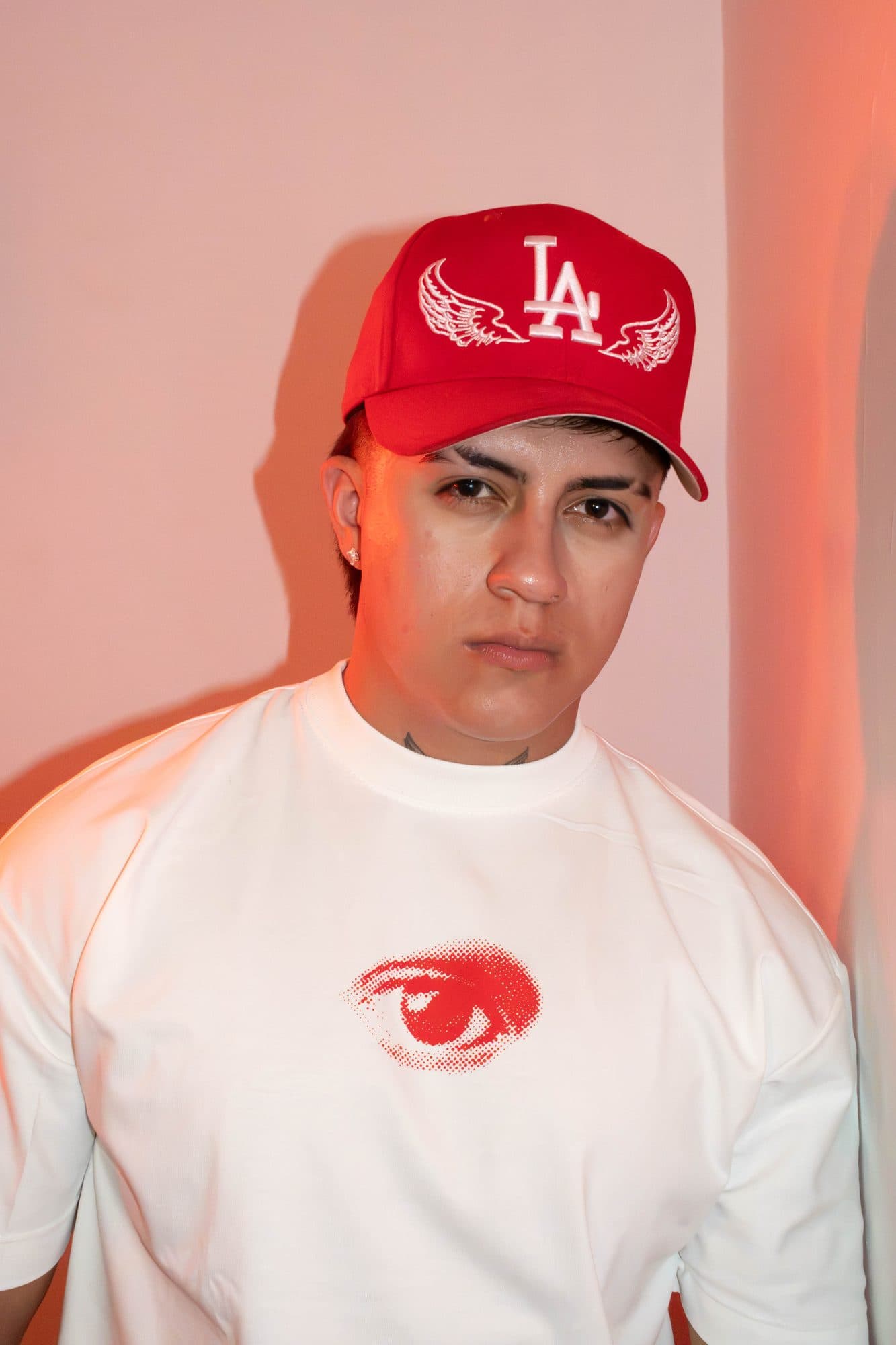Modelo de frente con la camiseta Disidencia blanca y el ojo rojo al pecho
