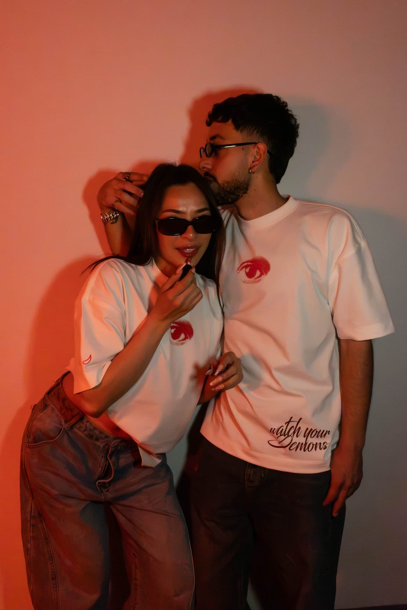 Pareja con la camiseta Disidencia; se ve Watch Your Demons en el ruedo