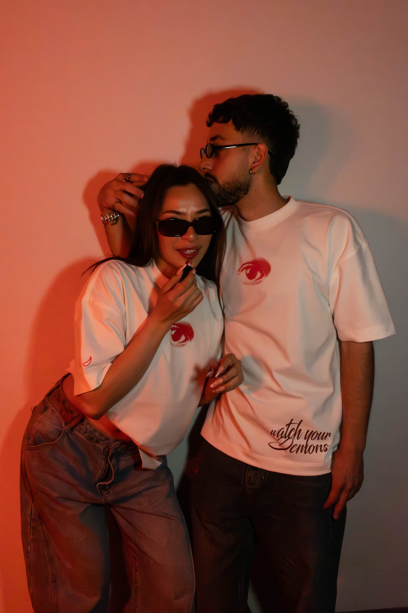 Pareja con la camiseta Disidencia; se ve Watch Your Demons en el ruedo